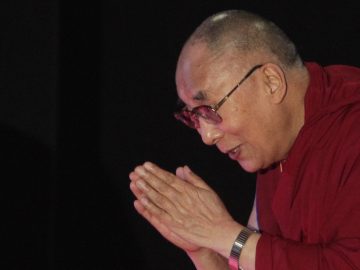 Tibetan spiritual leader the Dalai Lama greets the audience as he arrives to speak on "A Human Approach to World Peace" at Presidency College in Kolkata, India, Tuesday, Jan. 13, 2015. (AP Photo/Bikas Das)
